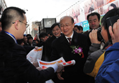 中国质量检验协会企业工作部主任陈平（左一）在2010年“3.15”咨询活动现场向时任国家质检总局副局长支树平汇报由中国质量检验协会主办的以